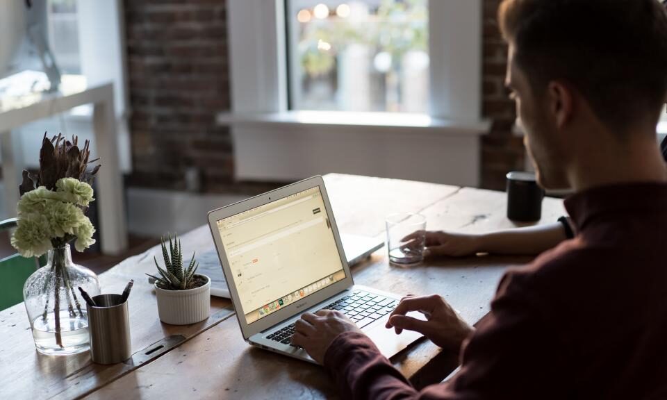 Arbeiten am Laptop an einem Schreibtisch am Fenster